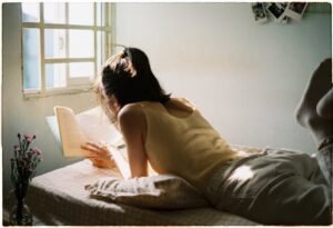 Woman Lying Down and Reading Book